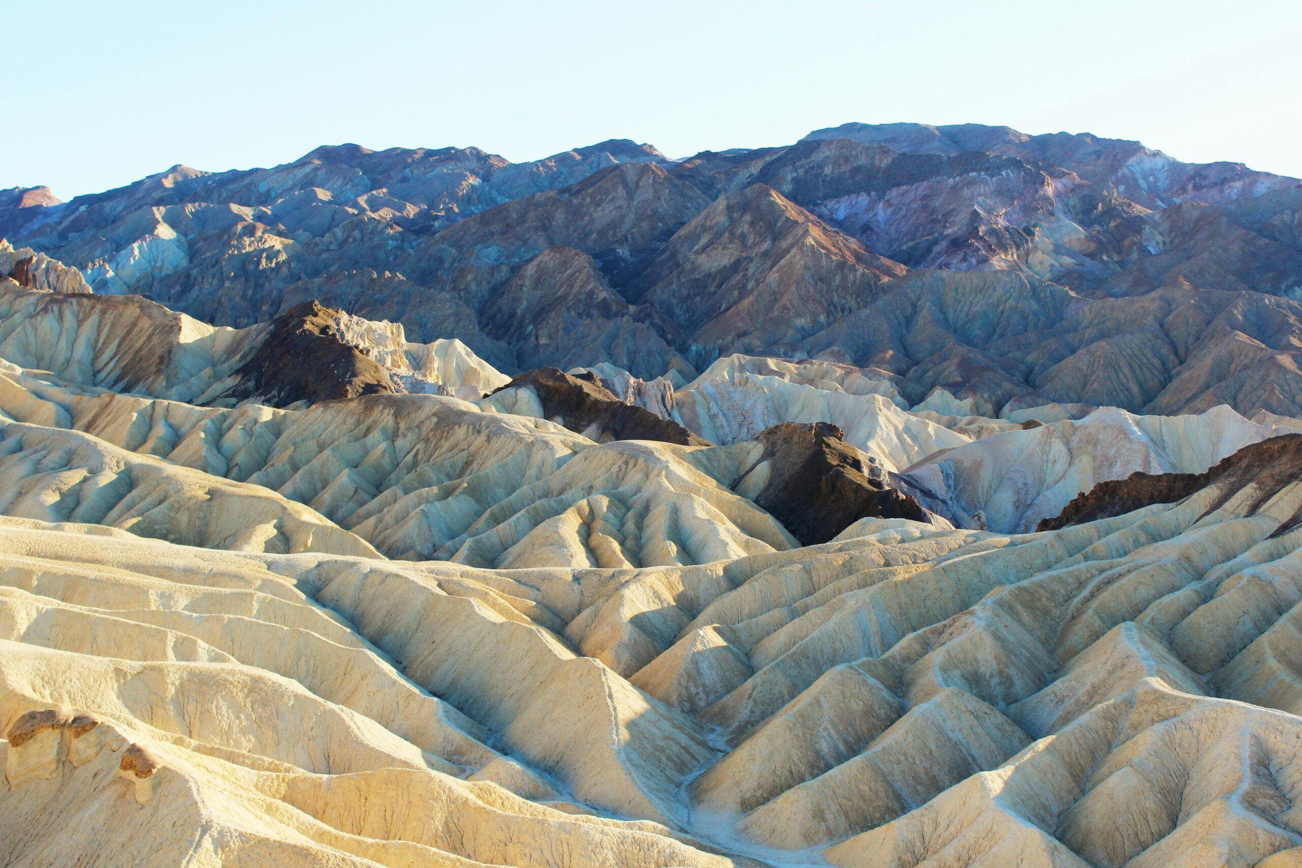 Explore the stunning geology of Zabriskie Point with its unique, rugged formations under the soft morning light.
